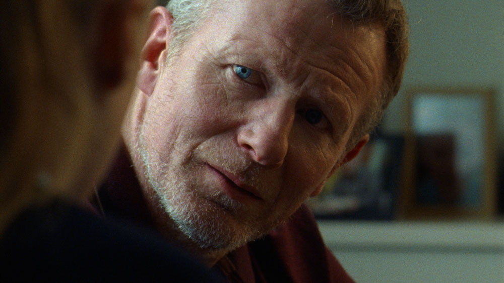 A man looks towards a young girl. He looks concerned.