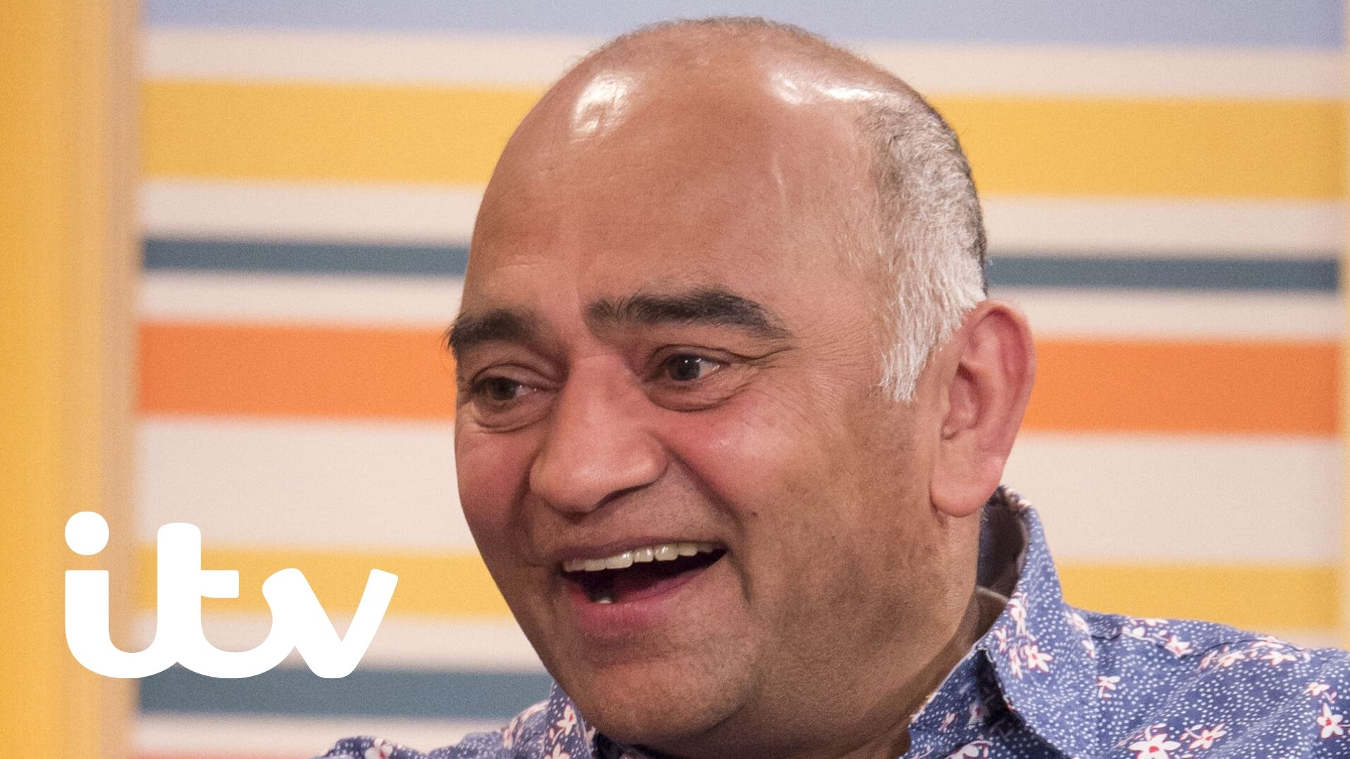 Actor Bhasker Patel, smiles whilst looking off screen.